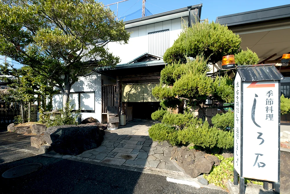 会席料理の焼き物と造り、吸い物が整った一人前の膳を落ち着いた照明の下で撮った写真
