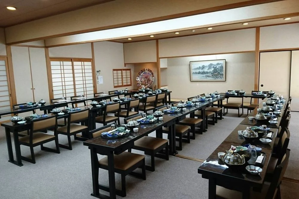 広めのテーブル席に料理が並び、複数名での会食準備が整った宴会席の様子